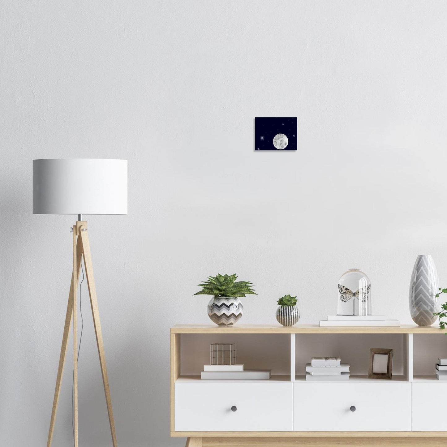 A canvas print of a night sky with a bright full moon and stars hanging above a desk.