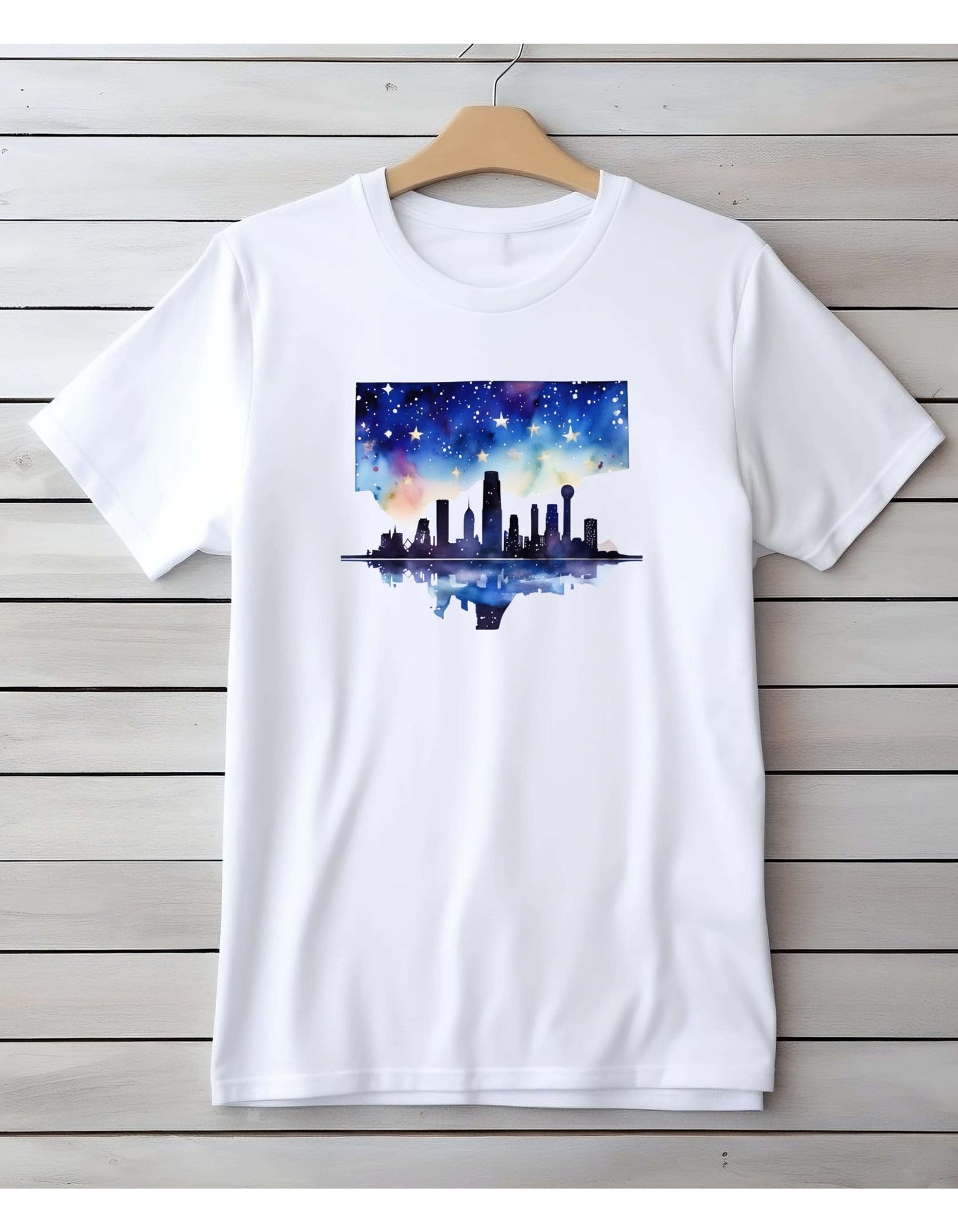White short sleeve t-shirt with the graphic of the skyline of downtown Dallas. The graphic is painted in water color style.