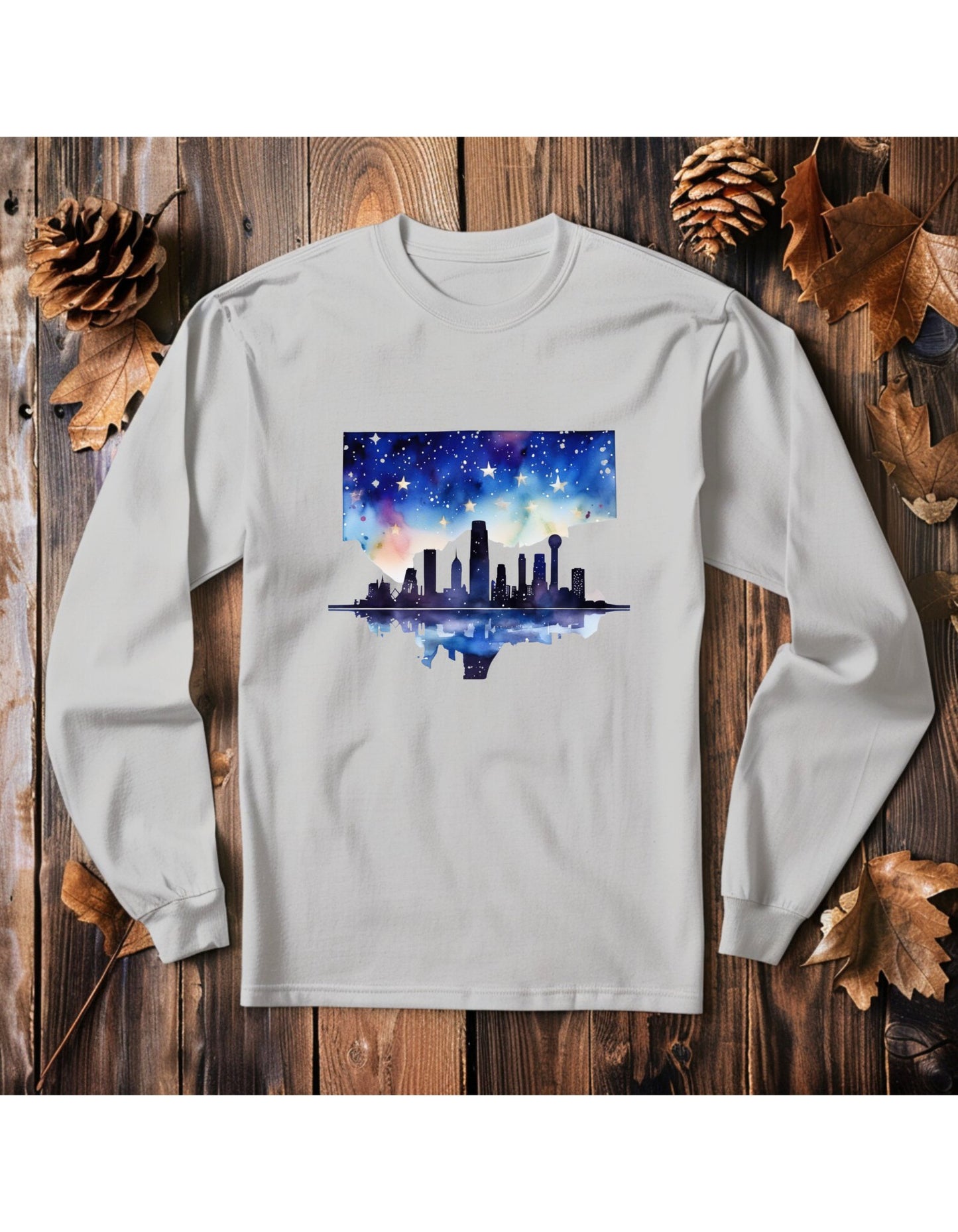 White long sleeve t-shirt with the graphic of the skyline of downtown Dallas. The graphic is painted in water color style.