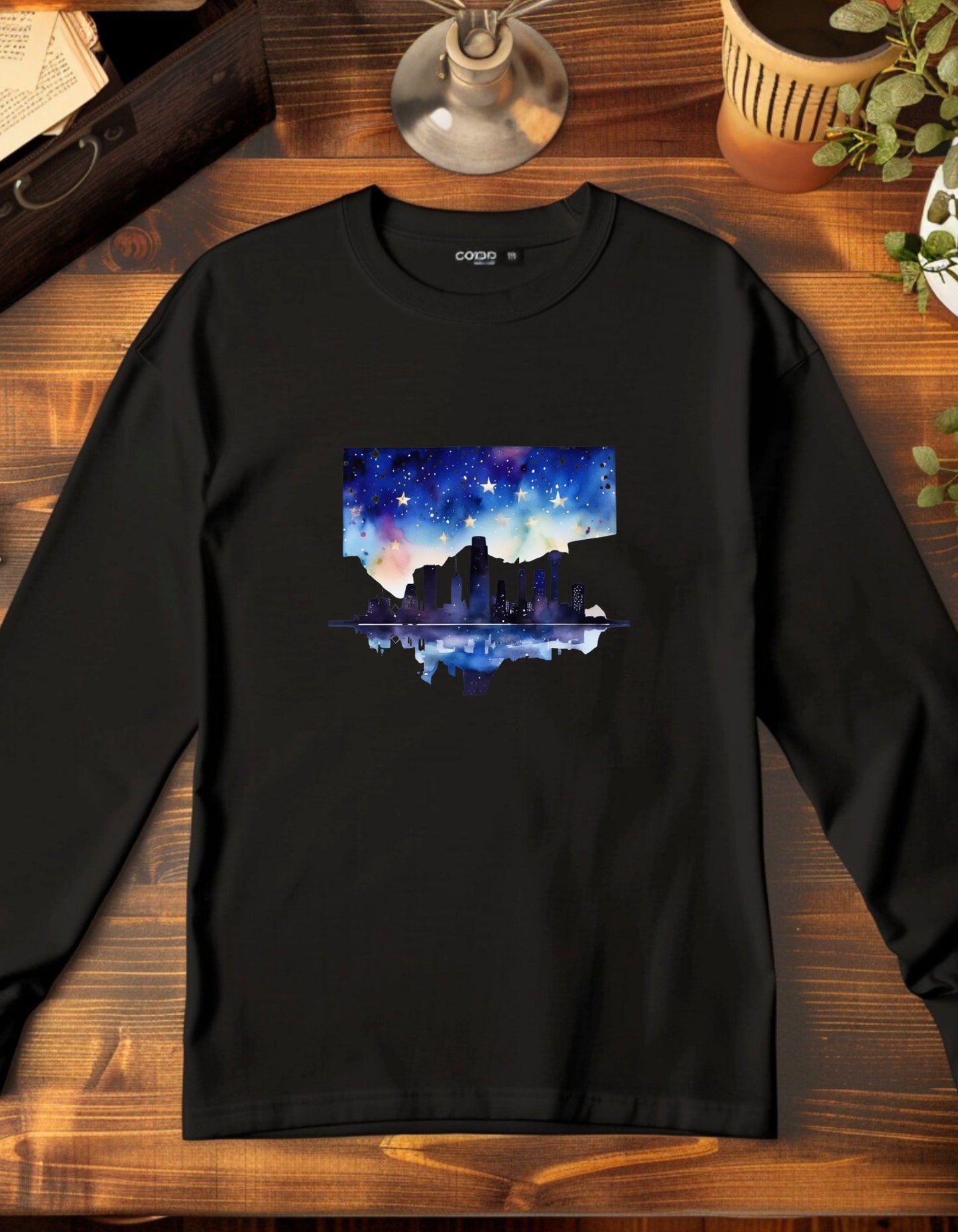 Black long sleeve t-shirt with the graphic of the skyline of downtown Dallas. The graphic is painted in water color style.